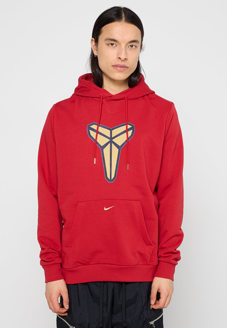 Roter Hoodie mit großem goldenen und marineblauen Grafiklogo. Kängurutasche, Kapuze mit Kordelzug und goldener Nike-Branding auf der Vorderseite.
