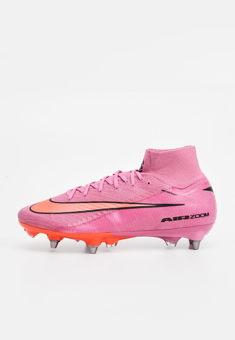 Pinker Fußballschuh mit strukturierter Oberseite, schwarzen und orangefarbenen Akzenten, mittelhohem Design und metallischen Stollen für besseren Halt.