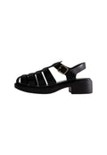 Schwarze Absatzsandalen mit offenem, gekreuztem Design. Hergestellt aus synthetischem Material, ausgestattet mit einem Schnallenriemen und einer strukturierten Sohle.
