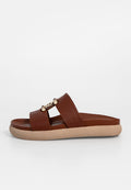 Braune Kunstleder-Sandalette mit zwei breiten Riemen. Mit goldfarbenem Akzent an der Vorderseite. Leichte beigen Außensohle mit texturiertem Finish.