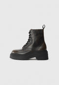 Schwarze Leder-Ankle-Boots mit Schnürung, dicke schwarze Sohle und einer Schlaufe auf der Rückseite, die den eingeprägten Markennamen an der Ferse zeigt.