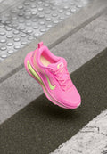 Nike-Laufschuh in knalligem Pink mit limettengrünen Akzenten. Obermaterial aus Mesh, runde Zehenpartie, Schnürdesign, strukturierte Sohle, markantes Branding auf der Zunge.