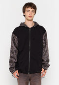 Schwarzer Hoodie mit grauen gesteppte Ärmeln, Reißverschluss, verstellbare Kapuze mit Kordelzug und Fronttaschen. Weicher Stoff mit sportlichem Design.