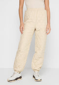 Beige gesteppte Hosen mit einem elastischen Bund, die über seitliche Taschen und schmal zulaufende Bündchen verfügen. Das Material hat eine weiche, gepolsterte Textur.