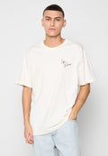 Cremfarbene Baumwoll-T-Shirt mit lockerer Passform, kurzen Ärmeln, Rundhalsausschnitt und einem kleinen schwarzen Schriftzug-Logo auf der linken Brust.