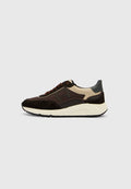 Brauner und cremefarbener Sneaker mit Obermaterial aus Wildleder und Mesh, ausgestattet mit einer klobigen weißen Zwischensohle und braunen Schnürsenkeln. Graue Akzente an der Ferse.