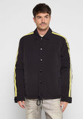 Schwarze gepolsterte Jacke mit gelben Seitenstreifen, Druckknopfverschlüssen und einem Kordelzugsaum. Sie hat einen leichten Glanz und Seitentaschen.