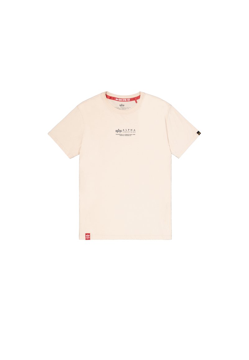 Beiges T-Shirt mit kurzen Ärmeln, kleinem schwarzem Alpha Industries-Logo und Text auf der Brust, rotem Etikett am unteren Saum und schwarzem Etikett am Ärmel.