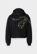 Schwarzer Cropped Hoodie mit Kapuze, der ein Pailletten-Schlangendesign in Silber und Schwarz auf der Vorderseite zeigt, aus einem weichen Stoff gefertigt.