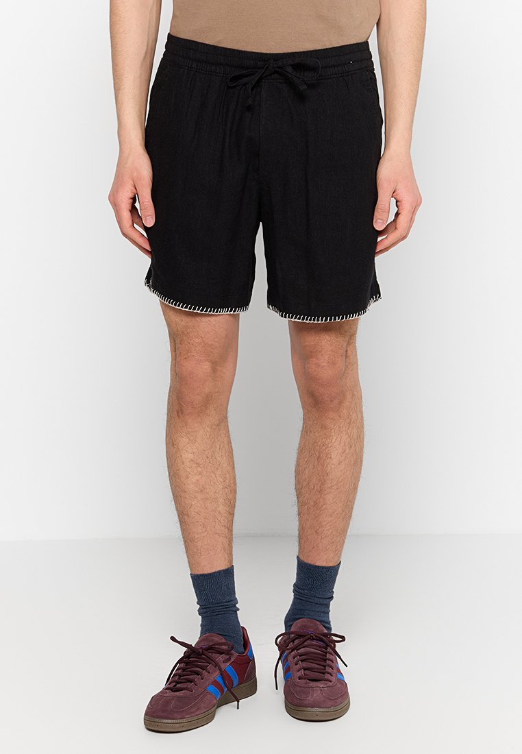 Schwarze Shorts aus Denim mit einem elastischen Bund und einer Kordel zum Verstellen, verziert mit kontrastierenden weißen Nähten am Saum.