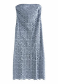 Trägerloses, hellblaues Kleid mit einem strukturierten Zickzackmuster, das ausgeschnittene Details und einen gewellten Saum aufweist. Aus atmungsaktivem Stoff gefertigt.