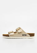 Beige Sandale mit offenem Zehenbereich, zwei verstellbaren Riemen, Korkfußbett, weißer Sohle und dem "BAYTON"-Logo auf der Seite.