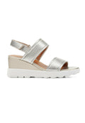 Silberne Keilsandalen mit zwei breiten Riemen, einer sandfarbenen Innensohle und einer strukturierten weißen Gummisohle. Verfügt über einen Slingback-Riemen für zusätzlichen Halt.