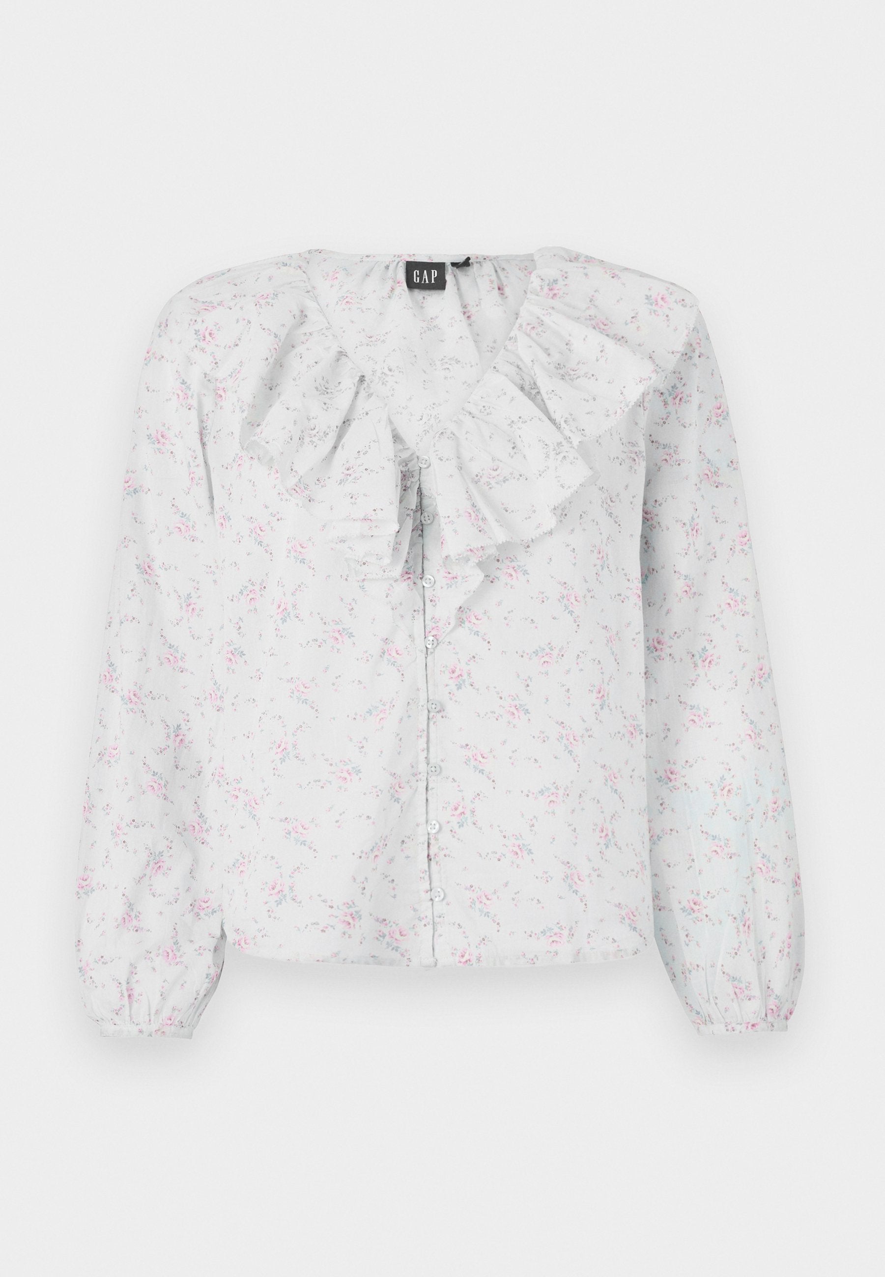 Weiße Bluse mit Rüschenausschnitt, floralen Mustern in Pink und Blau, langen Ärmeln und Knopfverschluss vorne. Leichter, strukturierten Stoff.