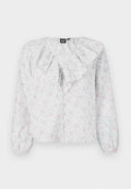 Weiße Bluse mit Rüschenausschnitt, floralen Mustern in Pink und Blau, langen Ärmeln und Knopfverschluss vorne. Leichter, strukturierten Stoff.