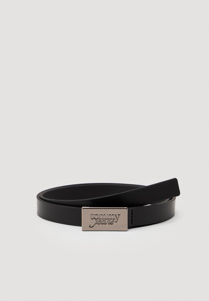 Schwarzer Lederhut mit einem eleganten Design, ausgestattet mit einer rechteckigen silbernen Schnalle, die mit "tommy jeans" geprägt ist. Glatte Textur, minimalistischer Stil.