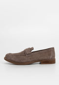 Braune Wildleder-Loafer mit einer abgerundeten Zehe, dekorativem Riemen über dem Obermaterial und einer kontrastierenden braunen Holzsohle. Einfaches Design, glatte Textur.