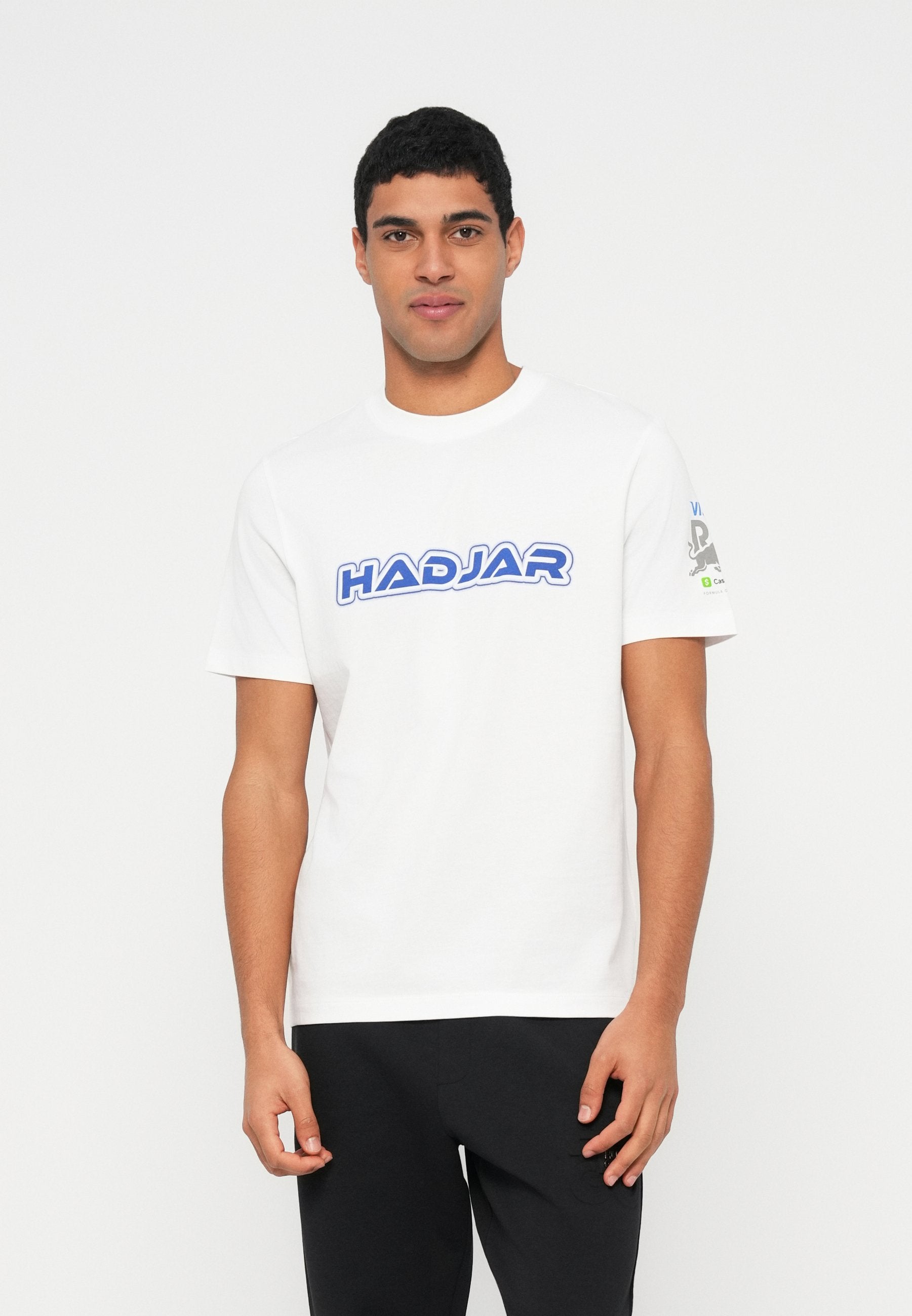 Weißes Baumwoll-T-Shirt mit blauem "HADJAR"-Schriftzug über der Brust und einem grafischen Detail am Ärmel. Kurze Ärmel und normale Passform.