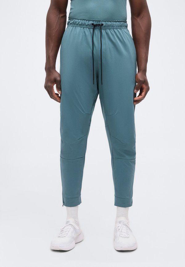 Nike Performance UNLIMITED - Tracksuit bottoms - mineral slate/black