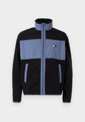 Fleecejacke mit hohem Kragen, schwarzer Körper und hellblauen oberen Teilen, mit Reißverschluss und zwei seitlichen Taschen.