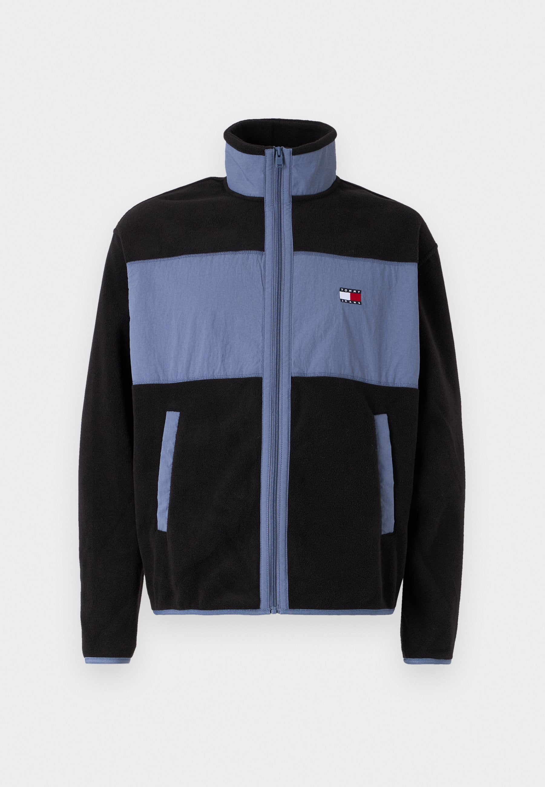 Fleecejacke mit hohem Kragen, schwarzer Körper und hellblauen oberen Teilen, mit Reißverschluss und zwei seitlichen Taschen.