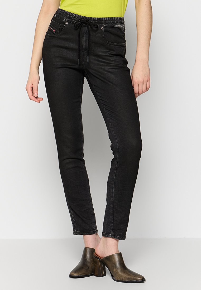 Schwarze Denim-Joggerhose mit elastischem Bund, Kordelzug und vorderen Taschen. Das Material hat eine glatte Textur und ein schlankes Design.
