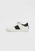 Weißer Sneaker mit niedrigem Schaft, schwarzer Ferse und seitlichem Streifen, Schnürverschluss und flacher Sohle vor schlichtem hellem Hintergrund.