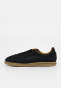 Schwarzer Wildleder-Sneaker mit rundem Zehenbereich, braunen Lederakzenten, strukturiertem Seitenlogo, flacher Gummisohle und kontrastierenden Schnürdetails.