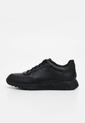 Schwarzer Low-Top-Sneaker mit Lederobermaterial, Schnürverschluss und strukturierter Gummisohle, von der Seite vor weißem Hintergrund dargestellt.