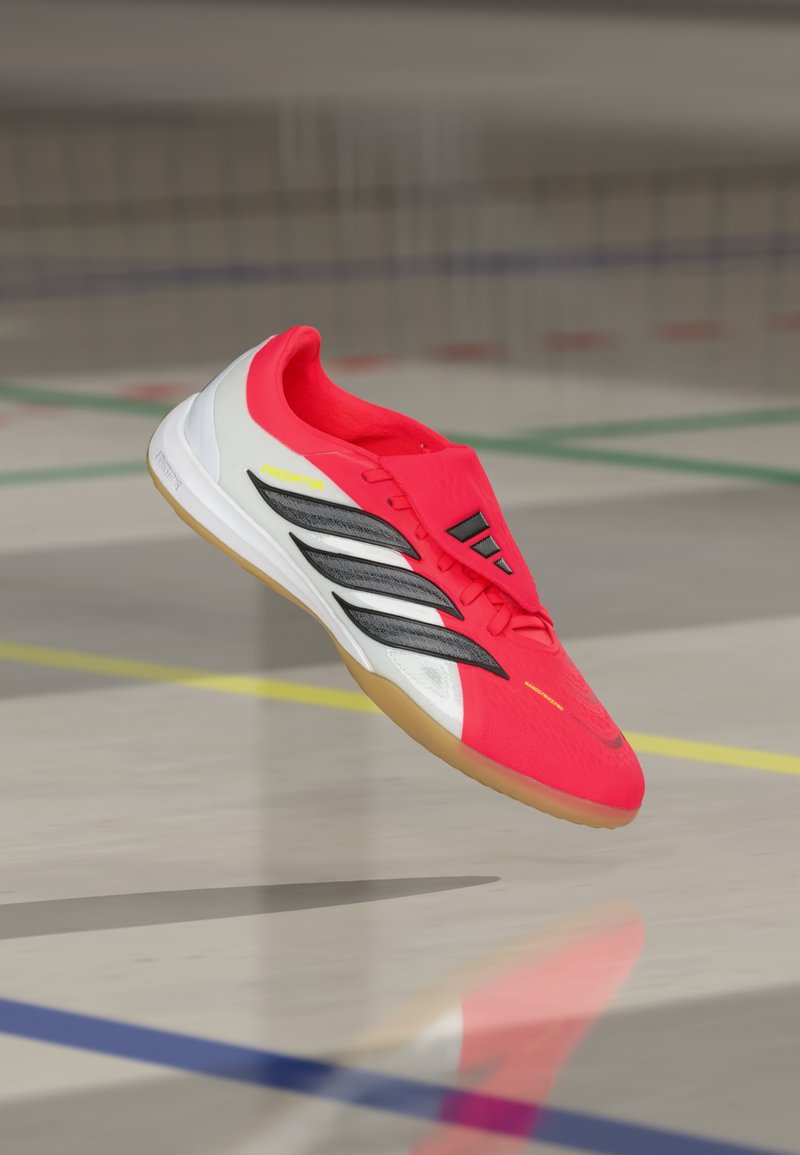 Roter Sportschuh mit einem leichten Mesh-Obermaterial, schwarzen Akzenten, weißer Ferse und Gummisohle. Verfügt über ein schlankes Design und eine enge Passform.
