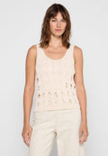 Beige gestricktes Tanktop mit runder Ausschnitt und durchbrochenen ovalen Mustern auf der Vorderseite, kombiniert mit hellen Hosen.