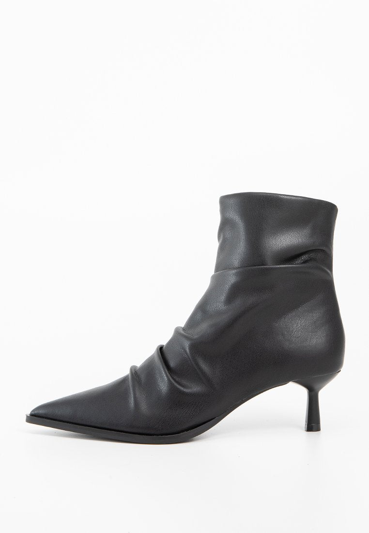 Schwarze Leder-Ankelboots mit einer lässigen Form, spitzem Zehenbereich und kleinem Kegelabsatz. Glatte Textur mit dezenten Falten.