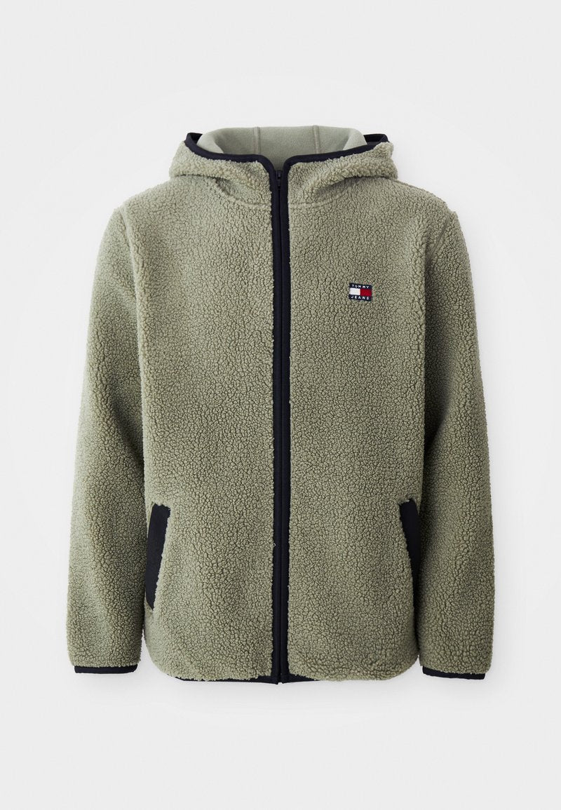 Fleecejacke in gedämpftem Grün mit Kapuze, Reißverschluss und schwarzen Akzenten an den Taschen und Bündchen. Kleines Logo-Patch auf der Brust.