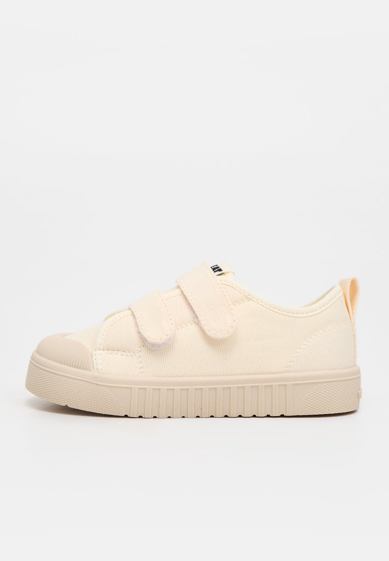 Beiger Sneaker mit niedrigem Schaft, Gummisohle und zwei verstellbaren Klettverschlüssen, entworfen für den Freizeitgebrauch.