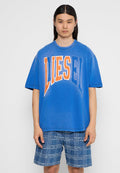 Blaues, oversized Baumwoll-T-Shirt mit "DIESEL" in großen orange- und weißen Buchstaben. Kombiniert mit karierten Jeansshorts. Einfache Hintergrund.