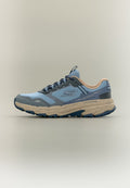 Niedriger Sportschuh in Blau und Beige mit Mesh-Obermaterial, gemusterter Sohle und seitlichem Logo, entworfen für Trailrunning und Wasserbeständigkeit.