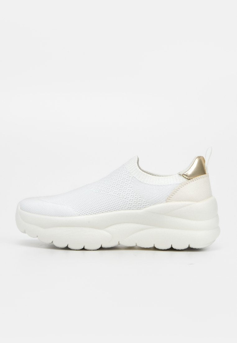 Weißer Slip-On-Sneaker mit gestricktem Obermaterial, dicker gepolsterter Sohle und metallisch goldenem Fersenlaschen auf schlichtem weißen Hintergrund.