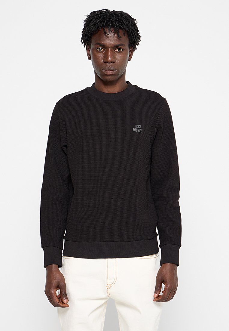 Schwarzer Ripp-Sweatshirt mit langen Ärmeln, rundem Halsausschnitt und kleinem "DIESEL"-Logo auf der Brust. Hergestellt aus strukturiertem Stoff.