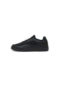 Schwarzer Sneaker aus glattem Leder und Textil, mit einer dicken Sohle, abgerundetem Zehenbereich und kontrastierenden Texturakzenten.