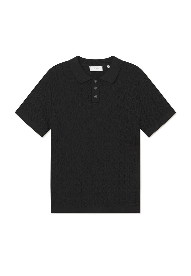 Schwarzes Poloshirt mit strukturiertem Muster, zwei Knöpfen am Ausschnitt und geripptem Kragen. Kurze Ärmel und gerader Saum.