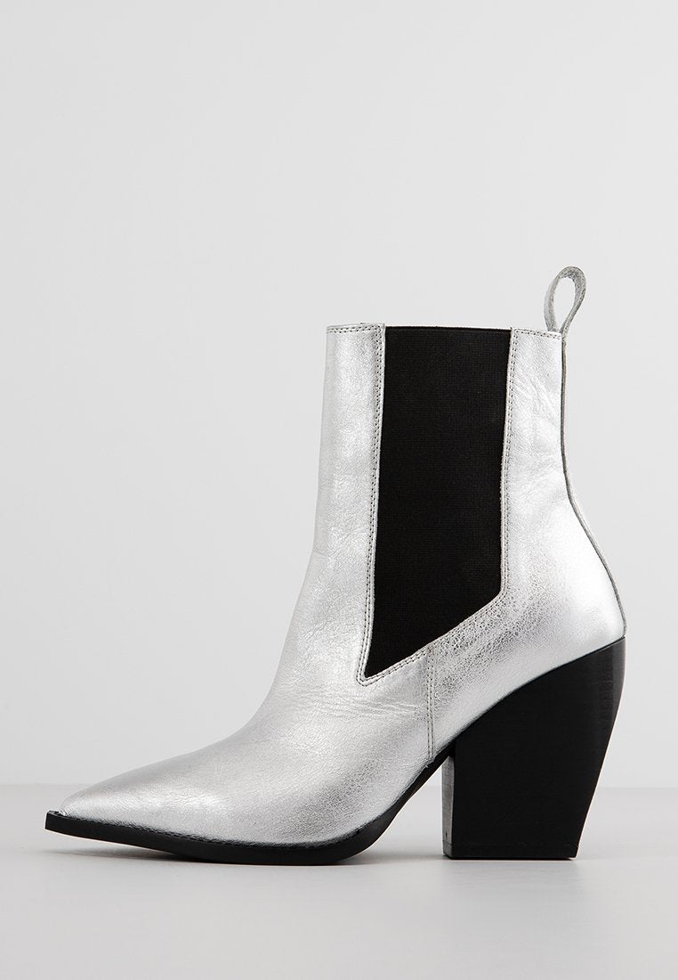 Silberner Stiefelette mit spitz zulaufender Schuhspitze, elastischem Seiteneinsatz und schwarzem strukturiertem Detail. Verfügt über einen klobigen schwarzen Absatz und ein glattes metallisches Finish.