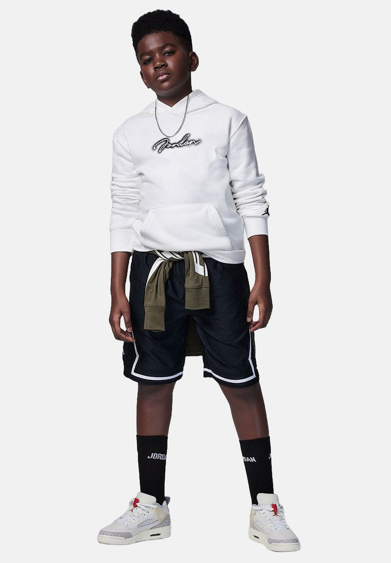 Weißer Hoodie mit "Jordan"-Logo, schwarze Shorts mit weißen Akzenten und grünem Bund, weiße Sneaker mit Akzenten, schwarze Crew-Socken.
