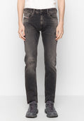 Schwarze Jeans aus Denim mit einem distressed Design, das sanfte Ausbleichungen und ausgefranste Knie-Details zeigt. Fünf-Taschen-Stil und ein Knopfverschluss.