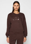Brauner Sweatshirt mit Rundhalsausschnitt, überschnittenen Schultern und „MCXX“ in glänzenden Paillettenbuchstaben. Hergestellt aus weichem, strukturiertem Stoff.