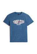 Blaues T-Shirt mit kurzen Ärmeln und Rundhalsausschnitt, mit "TOMMY JEANS" und "SINCE 1985" in Weiß und Rot als Logo zentriert auf der Brust gedruckt.