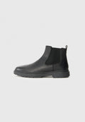 Schwarze Leder-Chelsea-Stiefel mit elastischen Seiteneinsätzen, einem Zugtab hinten und einer robusten Gummisohle für besseren Halt. Glatte Textur.