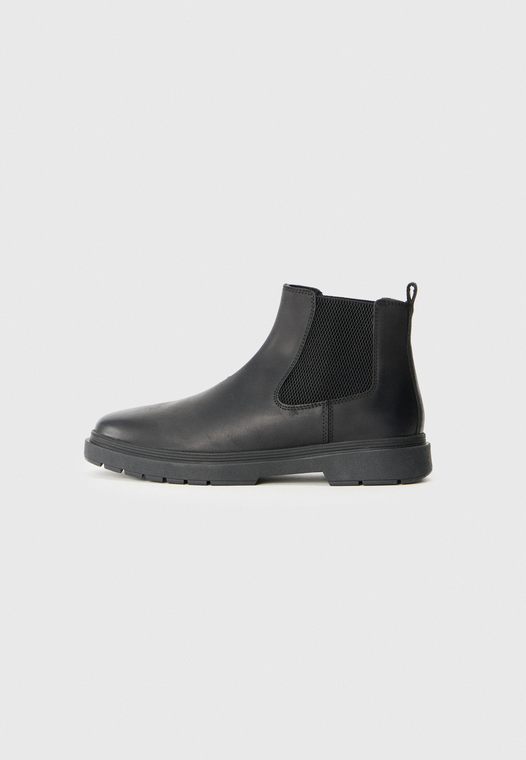 Schwarze Leder-Chelsea-Stiefel mit elastischen Seiteneinsätzen, einem Zugtab hinten und einer robusten Gummisohle für besseren Halt. Glatte Textur.