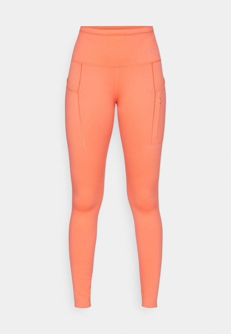 Hochgeschnittene, figurbetonte Leggings in leuchtendem Korallenrot, mit Seitentaschen und kontrastierenden Nähten für zusätzliche Details. Hergestellt aus dehnbarem Stoff.