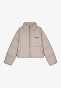 Beige cropped Puffer-Jacke mit hohem Kragen, Reißverschluss, zwei Vordertaschen und schwarzem Branding auf der Brust. Glatte, gepolsterte Textur.