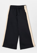 Schwarze weit geschnittene Sweatpants mit beigen Seitestreifen, ausgestattet mit einem elastischen Taillenbund und weichem Material. Dezentes Logo auf der Vorderseite.